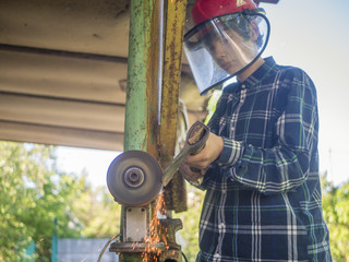 young person with axe working at the grinder