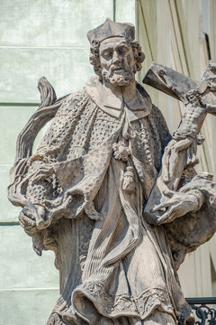 Statue of old priest with cross and Jesus at Old Town in Prague, Czech Republic