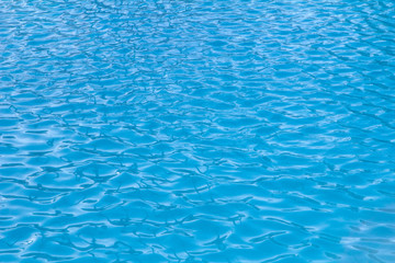 small waves and ripples on the blue water of the swimming pool