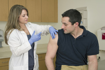 Medical Professional giving flu / vaccination shot to patient 