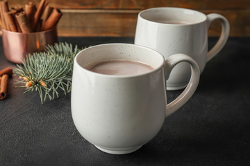 Cups with delicious hot cocoa drink on table