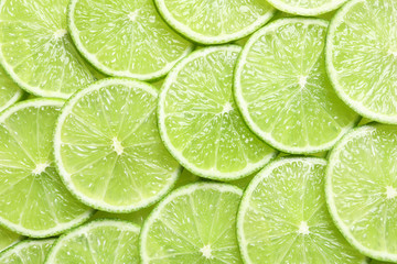 Fresh sliced ripe limes as background, top view