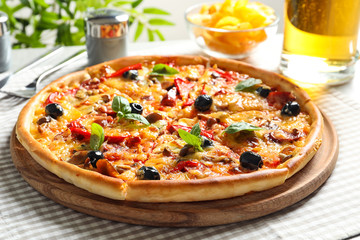 Delicious pizza with olives and sausages on table
