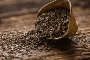 loose cumin seeds in a small wooden dish o a table