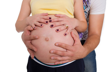 Close-up beautiful pregnant woman and her handsome husband hugging tummy