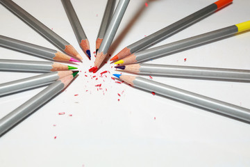 Color pencils lie in a circle on white background