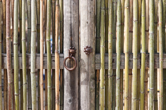 An old fashioned door woven from bamboo with doorknob.