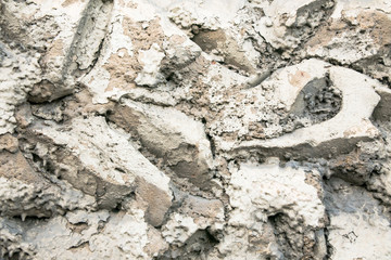 Close up of a rough textured plaster wall coating, imitation of stone masonry. Abstract grey patchy background.