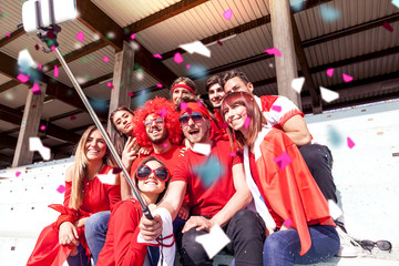 Fototapeta na wymiar group of fans dressed in red color takes a selfie