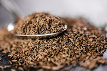 dry cumin seeds on a metal spoon