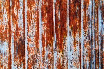 Rusty surface of metal sheets with the remains of light paint, metal texture.