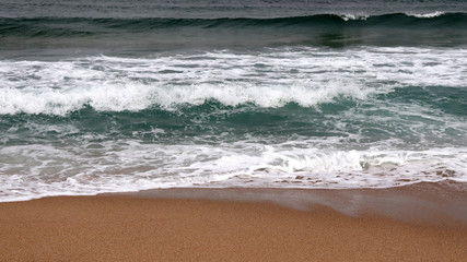 surf rolling onto white sand beaches