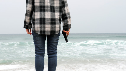 Close-up image of the girl with a gun on the beach.