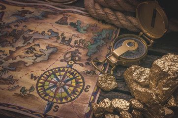 Treasure map, compass and gold nuggets on the table. Gold hunting concept.