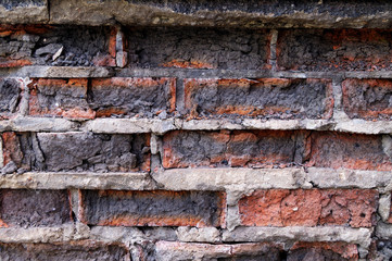 The old wall of bricks with the time of the destruction of the surface from time.