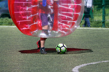 man on a sports field playing in the bumper ball