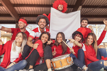 group of fans dressed in red color watching a sports event