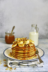Homemade hot banana pancakes with caramel sauce and nuts.