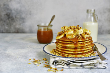 Homemade hot banana pancakes with caramel sauce and nuts.
