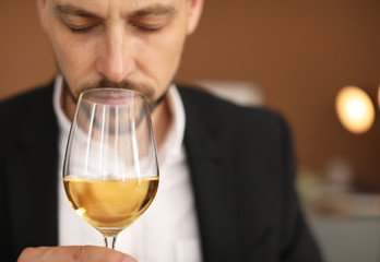 Young man with glass of wine indoors