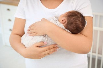 Fototapeta na wymiar Young mother holding cute newborn baby, closeup