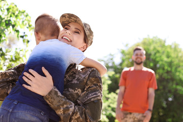Female soldier hugging with her son outdoors. Military service