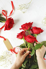 Fototapeta na wymiar Woman making a bouquet of red roses.