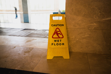 Warning sign for wet floors standing by the pool