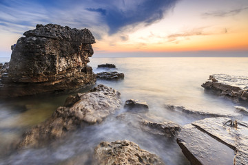 Fototapeta na wymiar Enjoying the colorful sunset on a beach with rocks on the Adriatic Sea coast Istria Croatia