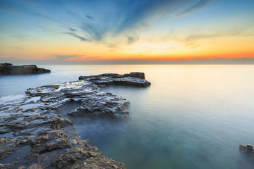 Enjoying the colorful sunset on a beach with rocks on the Adriatic Sea coast Istria Croatia