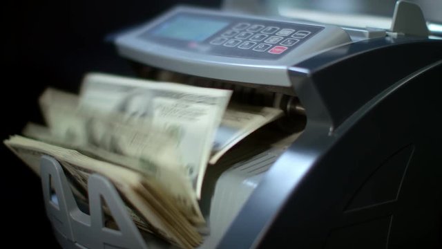 Electronic banknote counter counting dollar bills. Money counting machine. Currency counting equipment. Finance business concept. Automatic loan registration. Bank deposit proposition