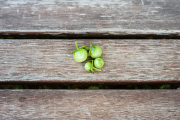 Small green cherry tomatoes on wooden boards