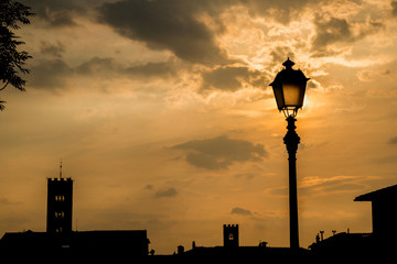 Lucca skyline with lamp at sunset