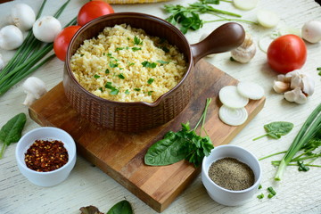 Bulgur in plate on wooden table. Traditional middle eastern or arab dish. Top view. vegetarian dinner. Bulgur  with vegetables, spices on white background. Flat la