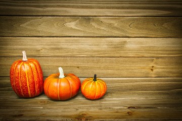 Pumpkins with a wood background providing copy space.