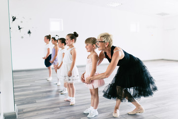 Obraz premium Group of beautiful little girls practicing ballet at dancing class.