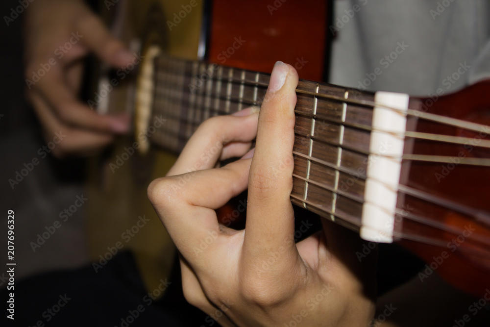 Wall mural close up of young man playing guitar.