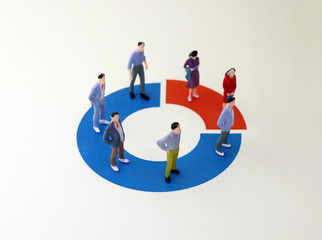 Miniature men and women standing on a donut graph. Concept of gender employment difference...