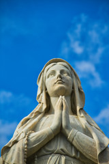 Fototapeta premium A statute of the Virgin Mary looking up while praying.