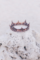crown lying on stone on the beach