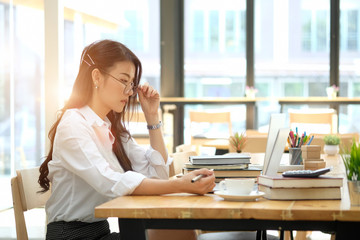 Obraz premium Businesswoman working on laptop at workplace in office or co-working space.