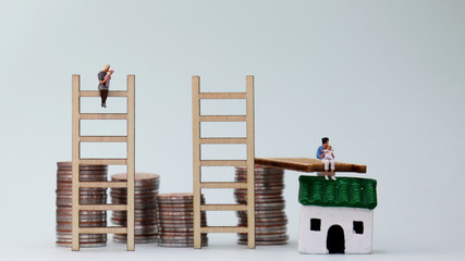 A miniature woman holding a baby and a pile of coins. The concept of career breaks for...