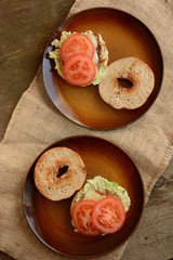 fresh  sandwiches with meat, cheese, bacon, tomatoes, lettuce, cucumbers and onions on wooden background 