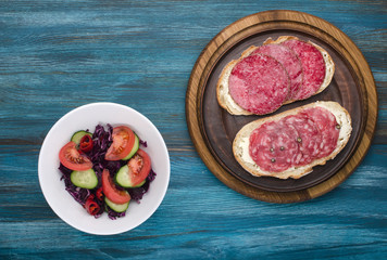 plate of sandwiches with salami and salad