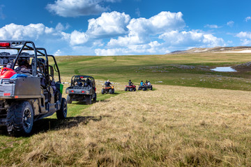 Friends driving off-road with quad bike or ATV and UTV vehicles