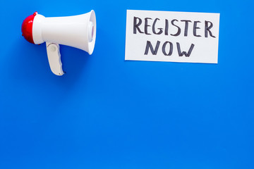 Register now hand lettering icon near megaphone on blue background top view copy space