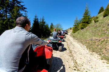 A tour group travels on ATVs and UTVs on the mountains