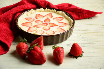 Strawberry pie on wooden board with plate of srawberry. Fruit tarts with sweet fresh strawberries. Freshly baked cake, biscuit.  