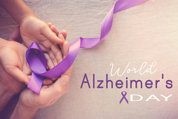 Hands holding Purple ribbons, world Alzheimer's day