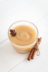 Apple sauce, puree in a glass with spices on a white wooden table  